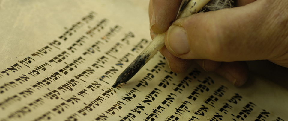 Scribe writing Hebrew text.