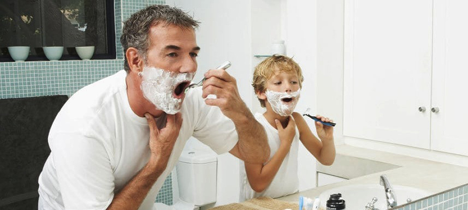 Father and son shaving.